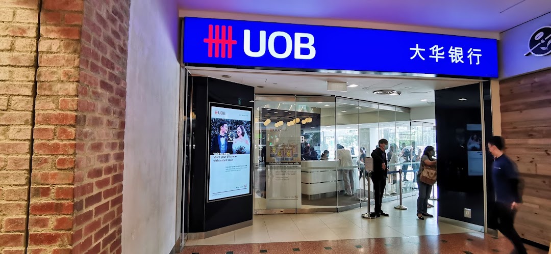 The UOB bank branch entrance at Jurong Point, with customers inside and a digital display.