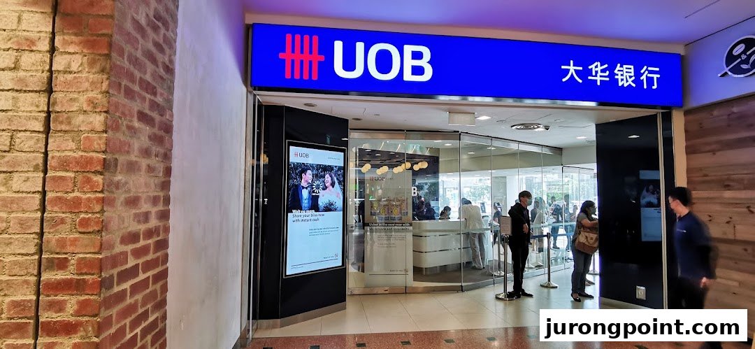 The UOB bank branch entrance at Jurong Point, with customers inside and a digital display.