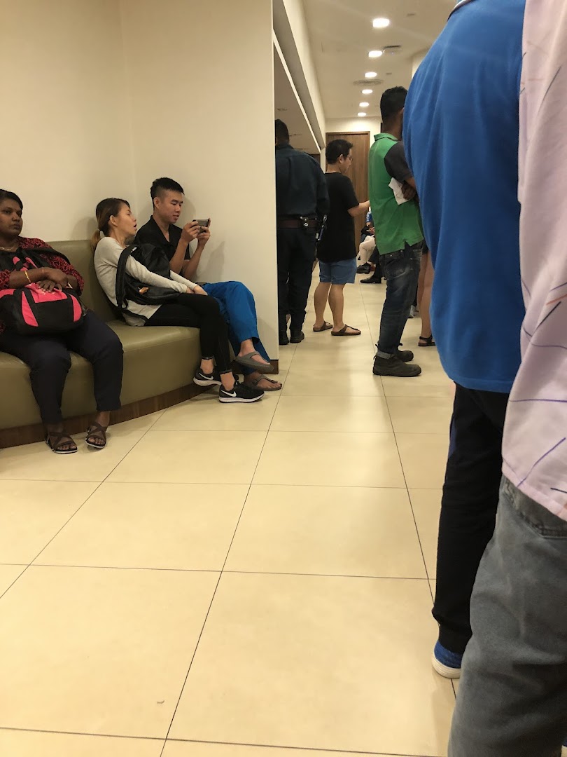 Customers waiting in a UOB bank branch, some seated, others standing in line.