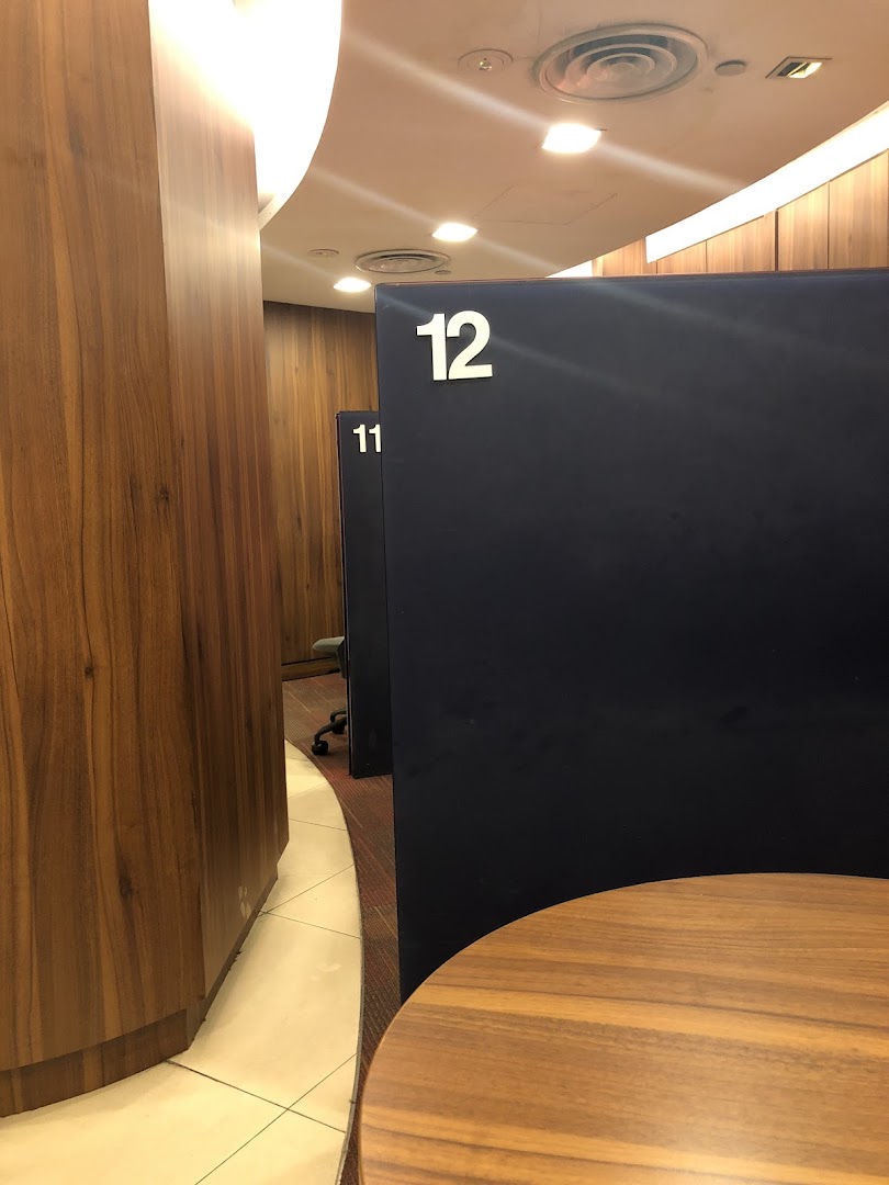 Interior view of UOB bank branch with numbered private booths and modern wooden paneling.