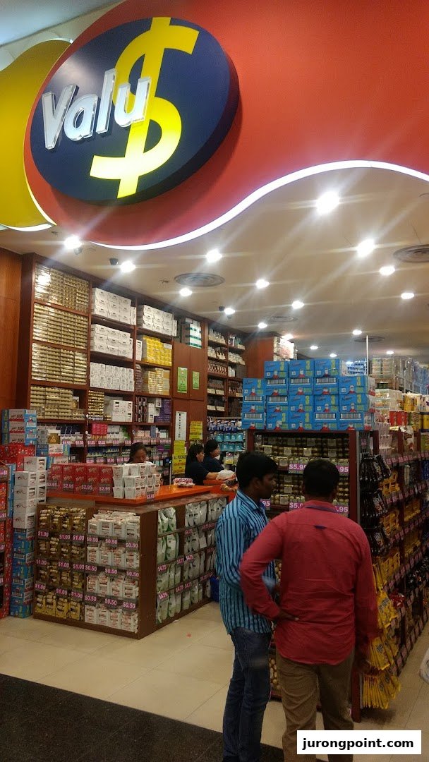 Interior view of Valu store, showcasing diverse products, shelves, and customers shopping.