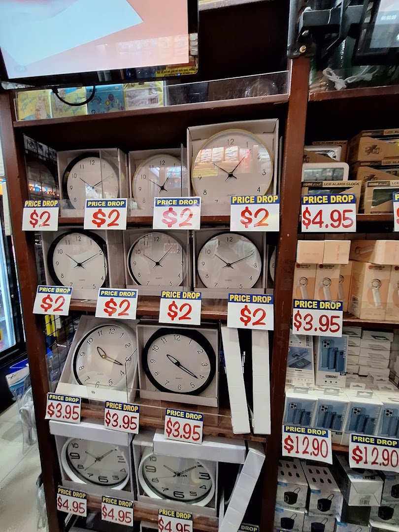 A retail display shelf at Valu showcasing various clocks and electronics with prominent 'Price Drop' signs.