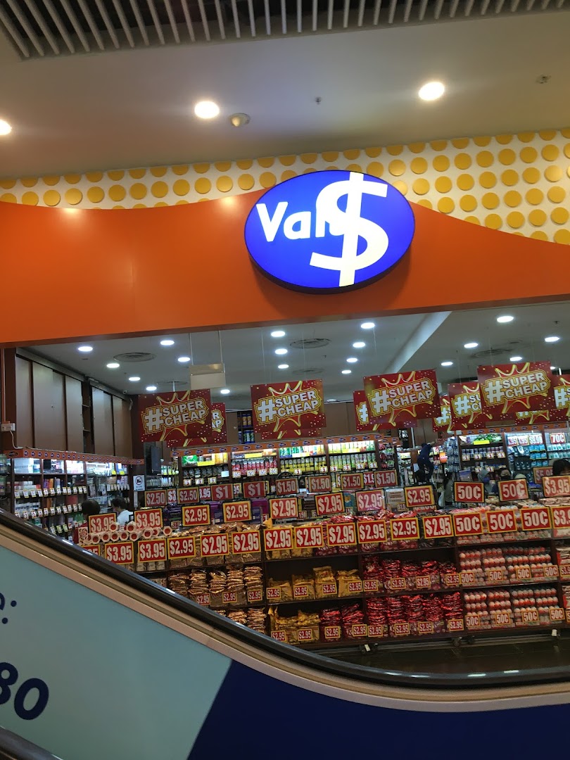 View of Valu shop entrance with its distinctive logo and shelves filled with discounted products, seen from an escalator.