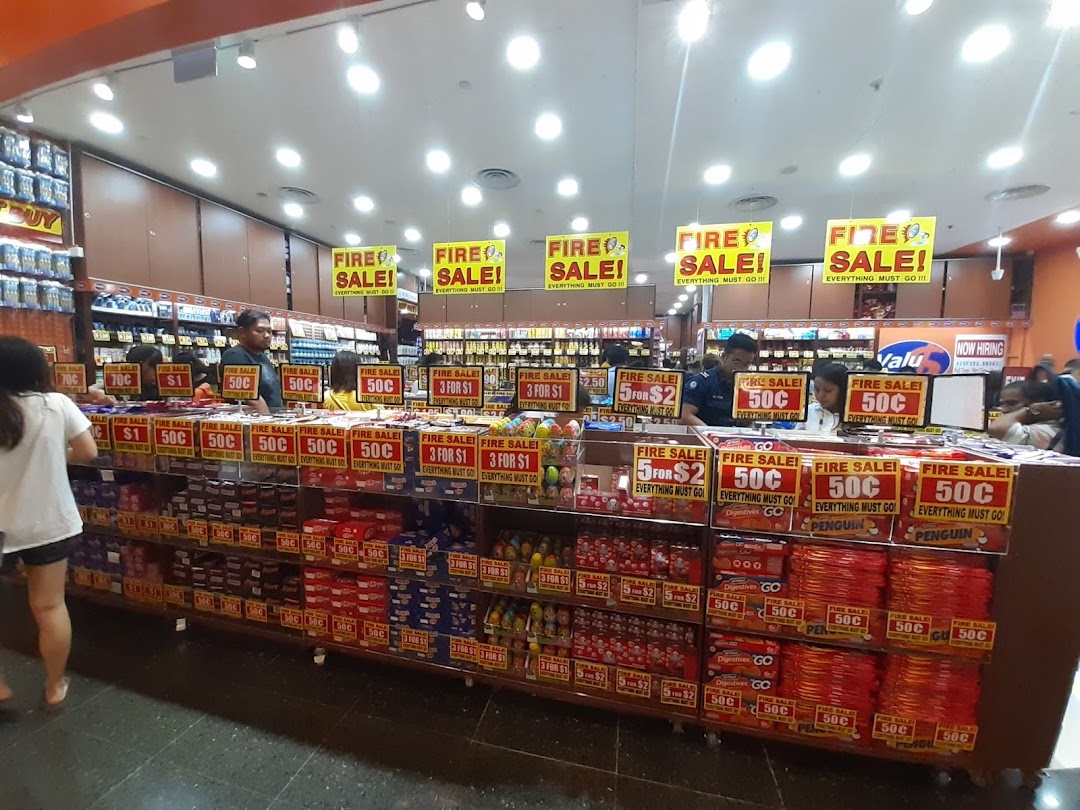 Interior view of Valu store showcasing a "Fire Sale" with various discounted products and shoppers.