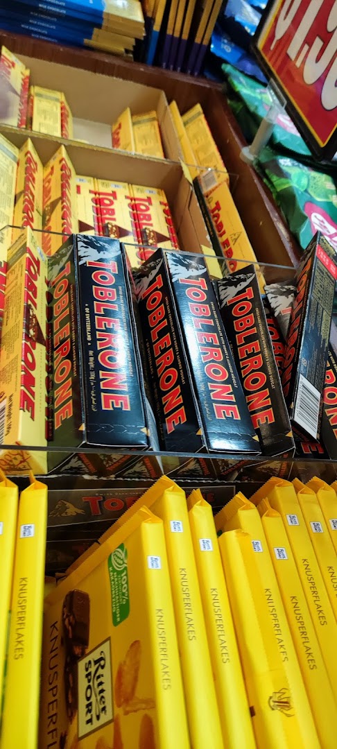 Shelves stocked with Toblerone and Ritter Sport chocolate bars in a retail store.