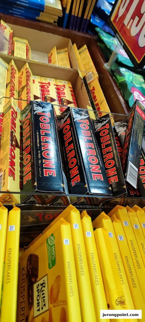 Shelves stocked with Toblerone and Ritter Sport chocolate bars in a retail store.