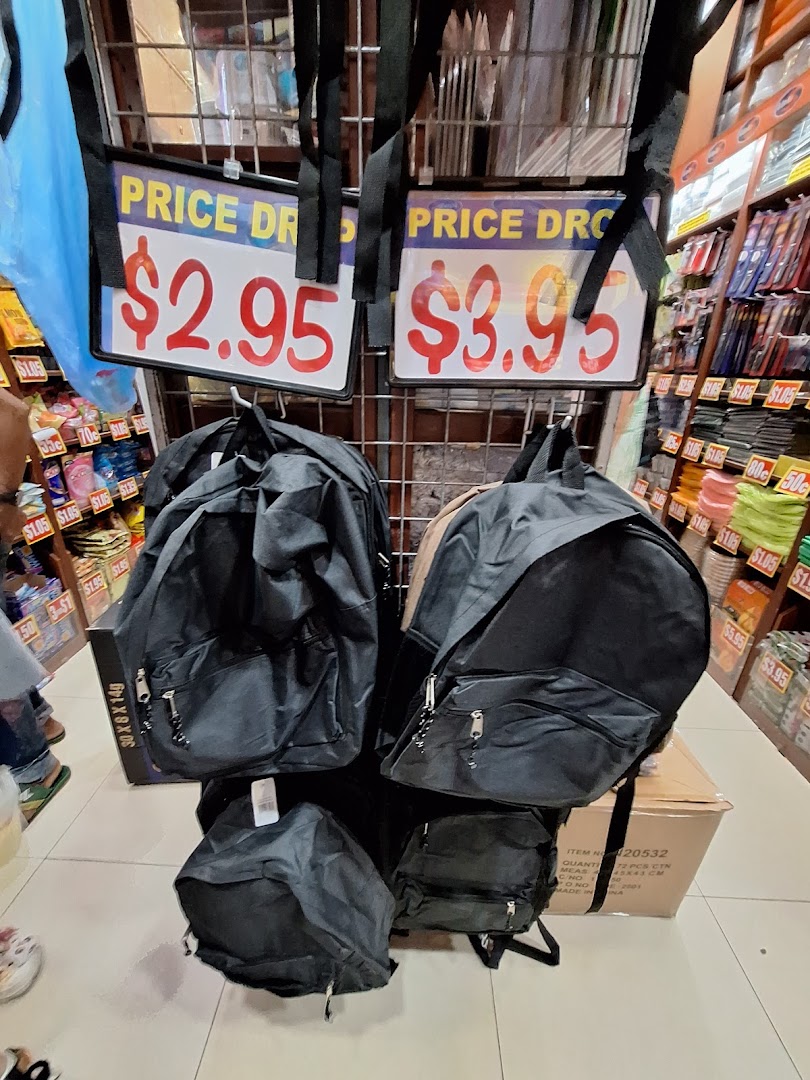Black backpacks displayed for sale with 'Price Drop' signs at $2.95 and $3.95 in a retail store.