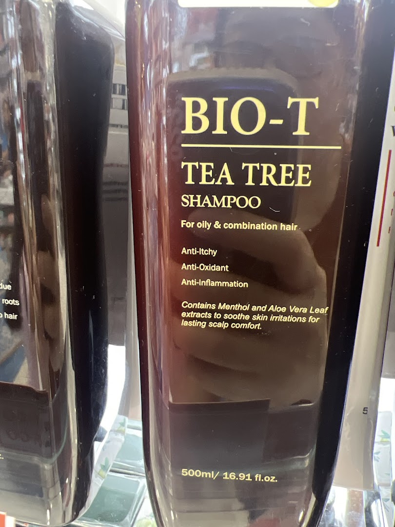 A close-up of a BIO-T Tea Tree Shampoo bottle, highlighting its benefits for oily and combination hair.