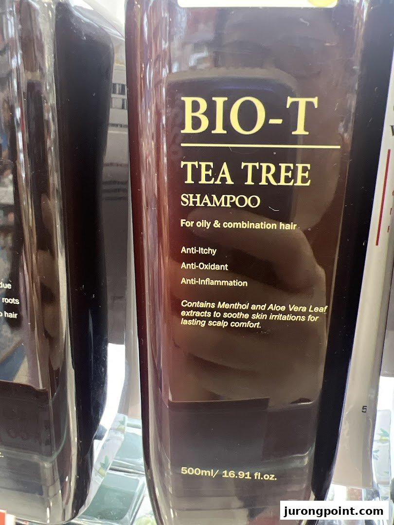 A close-up of a BIO-T Tea Tree Shampoo bottle, highlighting its benefits for oily and combination hair.