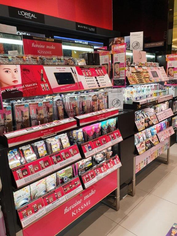 An in-store display featuring makeup products from L'Oréal, Maybelline, and Heroine Make at Watsons.