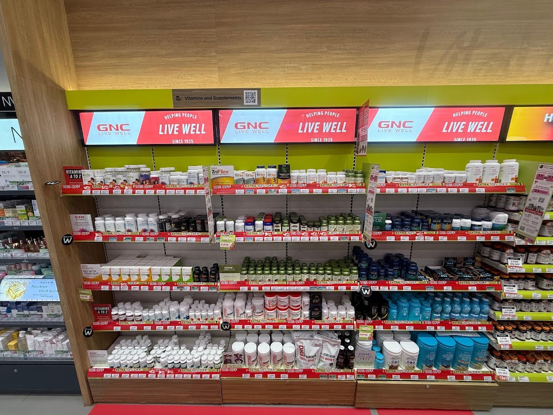 Shelves at Watsons Singapore Pharmacy displaying a wide range of GNC vitamins and health supplements.