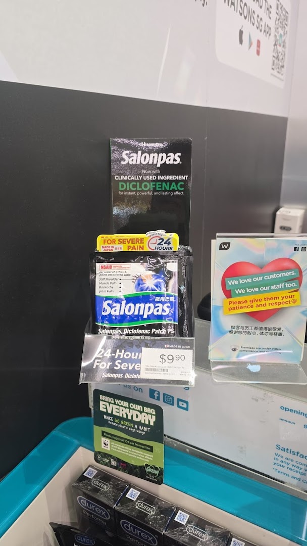 An in-store display at Watsons featuring pain relief patches, personal care items, and customer service signage.