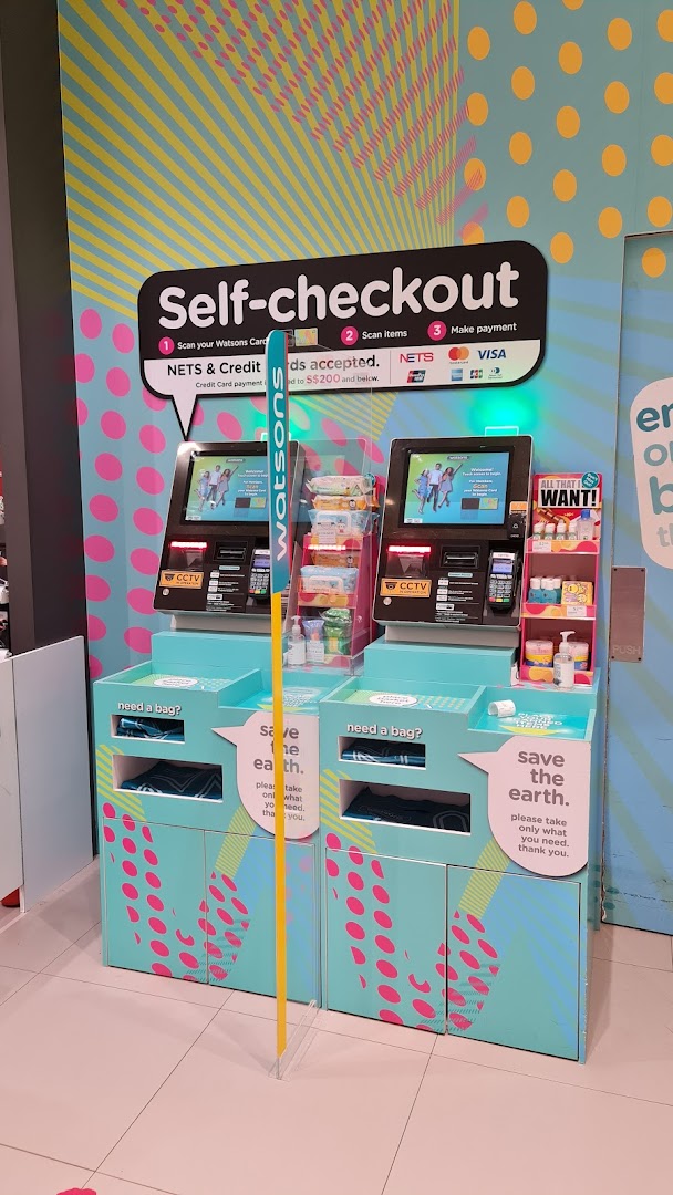Two Watsons self-checkout kiosks with clear instructions and payment options in a brightly decorated area.