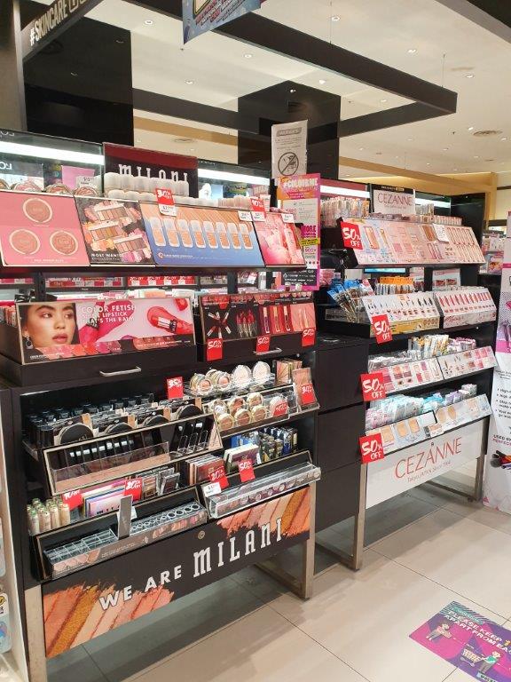 Interior view of a Watsons store showcasing Milani and Cezanne makeup displays with various beauty products.