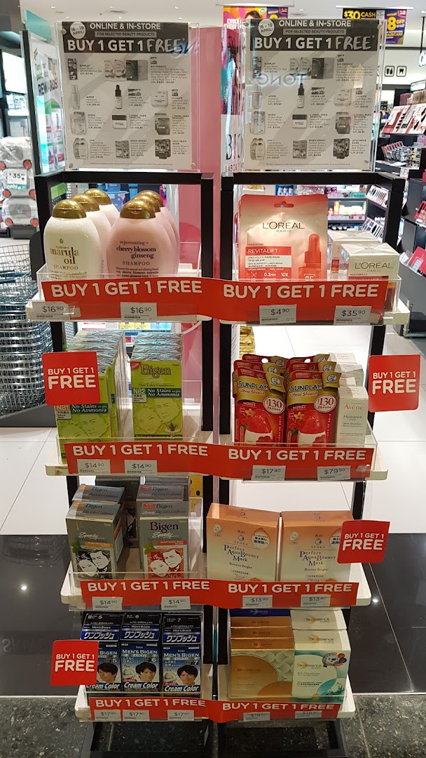A retail display stand inside Watsons, featuring beauty and health products with 'Buy 1 Get 1 Free' promotions.