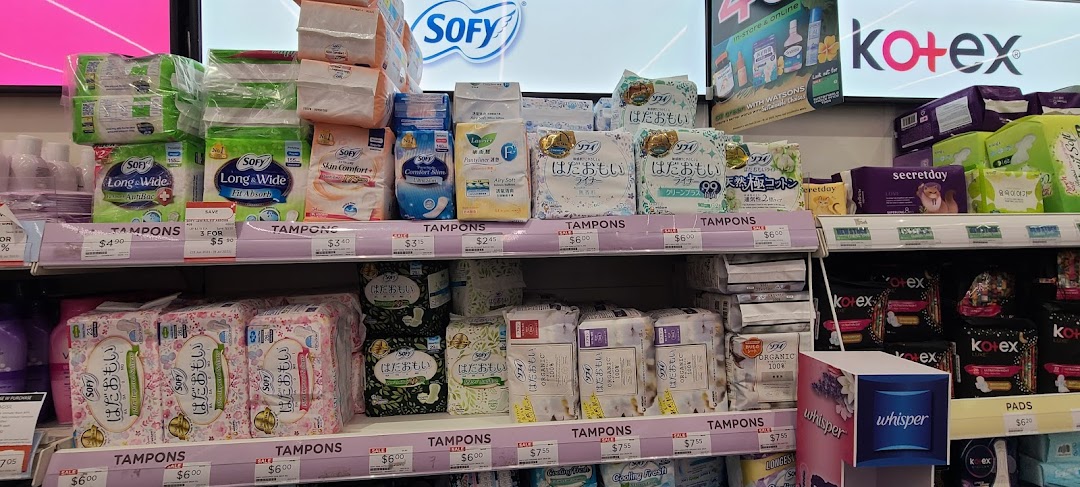 A well-stocked retail shelf inside Watsons, featuring a wide array of feminine hygiene products and personal care items.