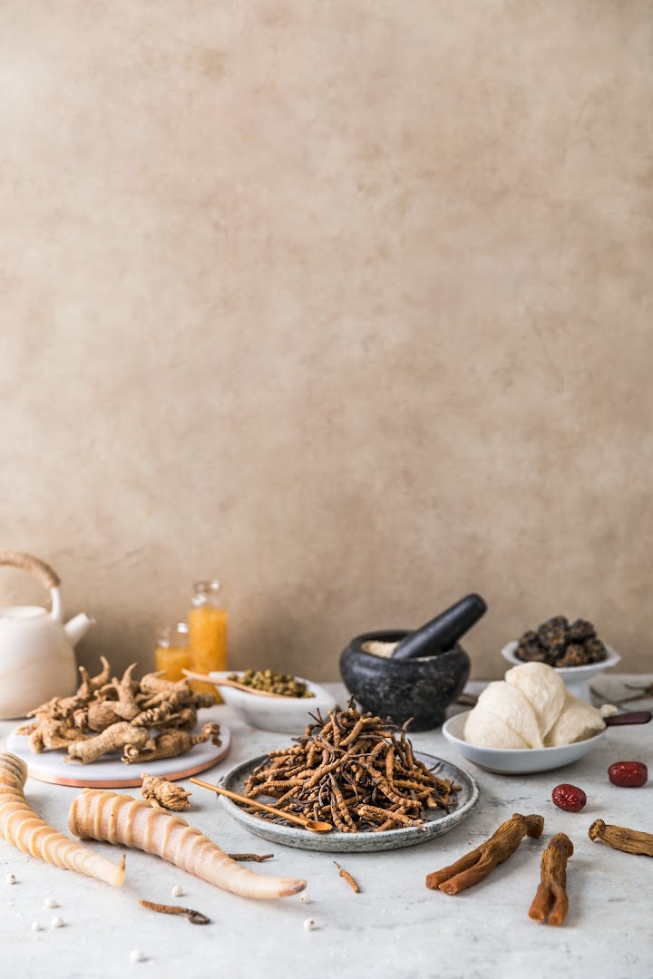 An assortment of traditional Chinese medicinal ingredients, including ginseng, cordyceps, and bird's nest, arranged on a table.