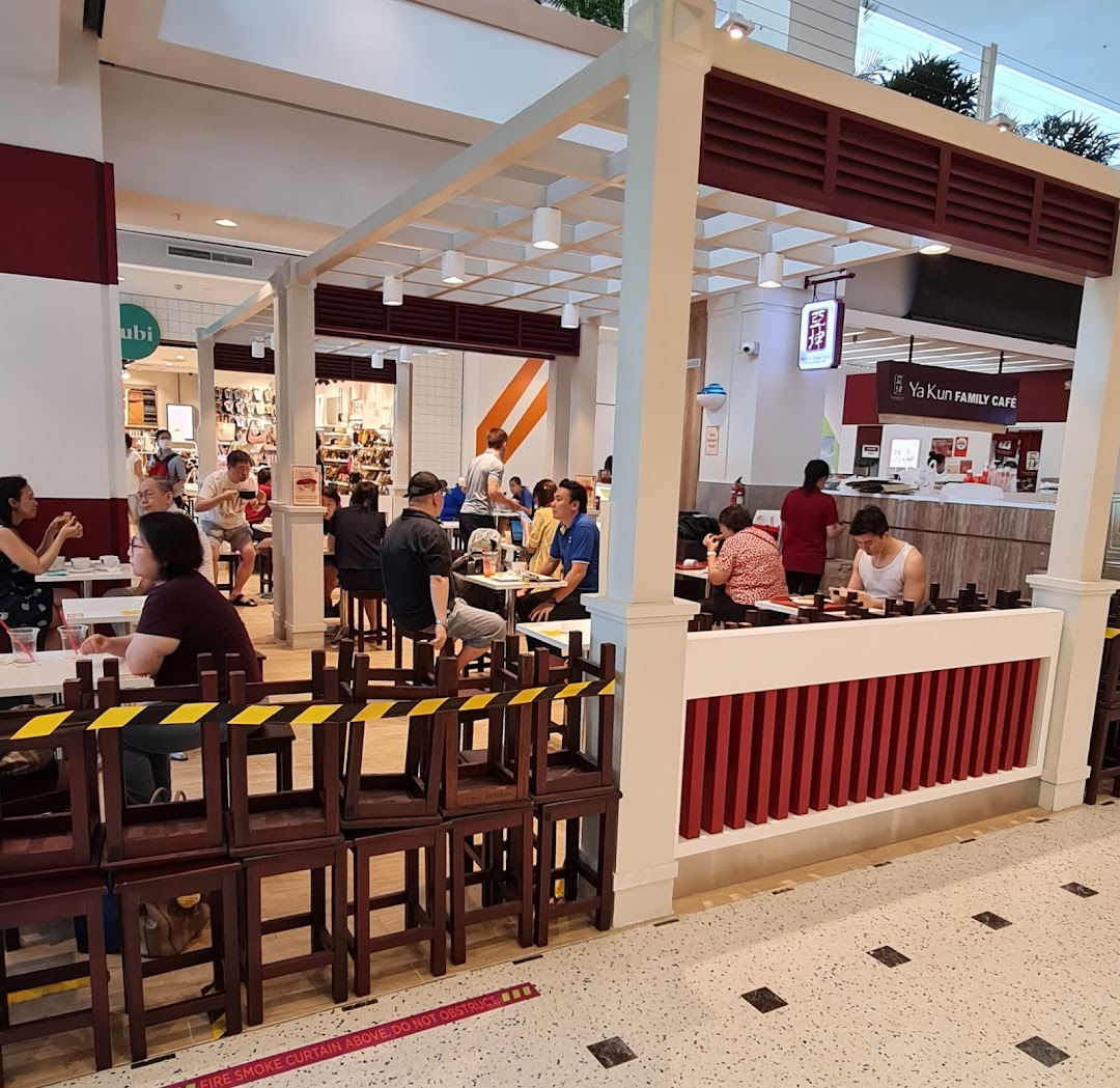 Customers enjoy traditional Singaporean breakfast and snacks in a bustling Ya Kun Family Cafe setting.