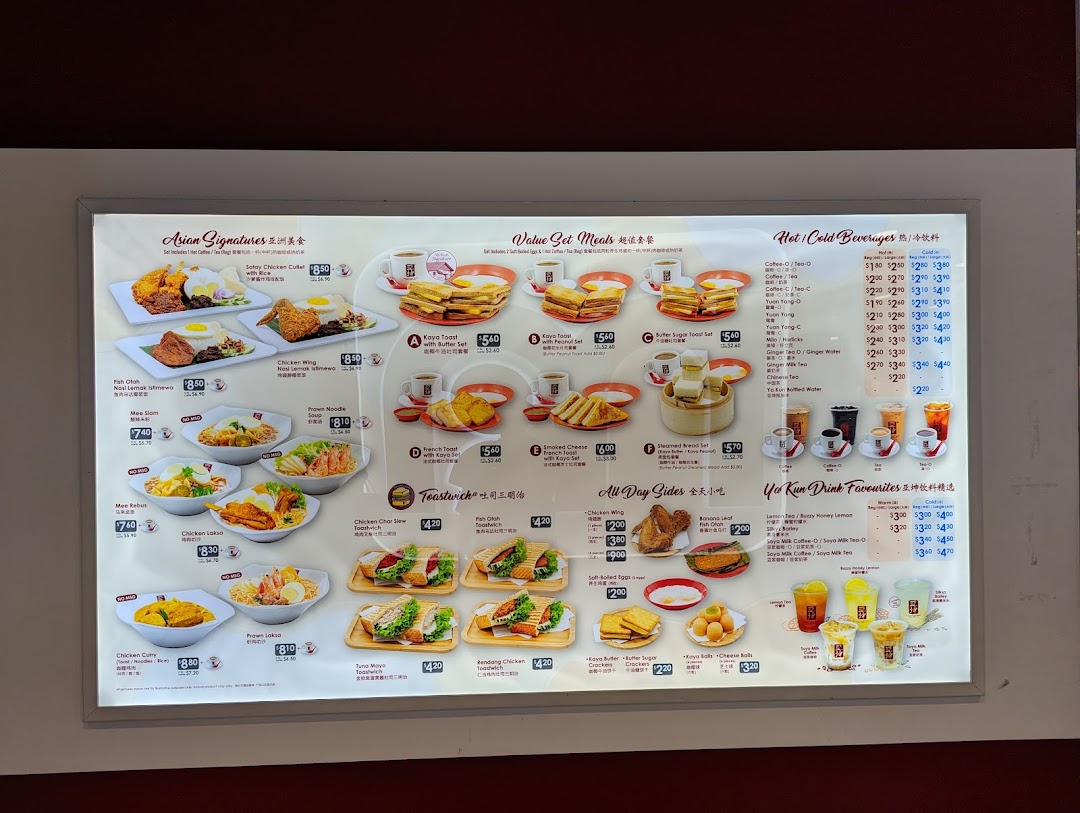 A brightly lit menu board displaying a variety of Asian signature dishes, value sets, beverages, and sides.