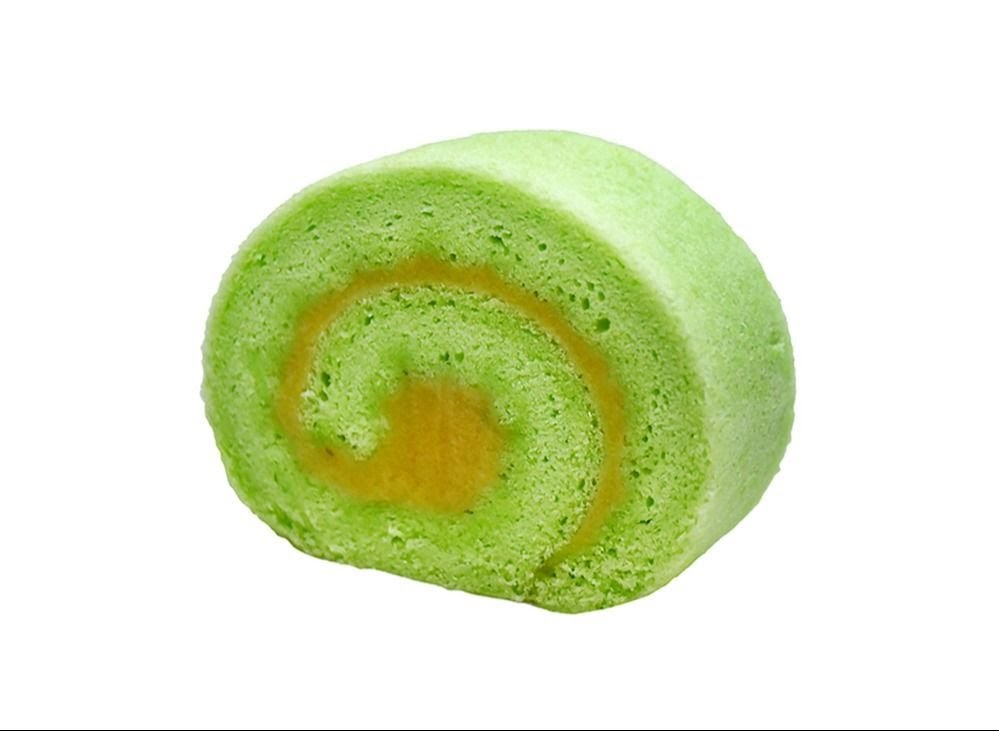A vibrant green pandan cake roll with a golden-yellow filling, isolated on a white background.