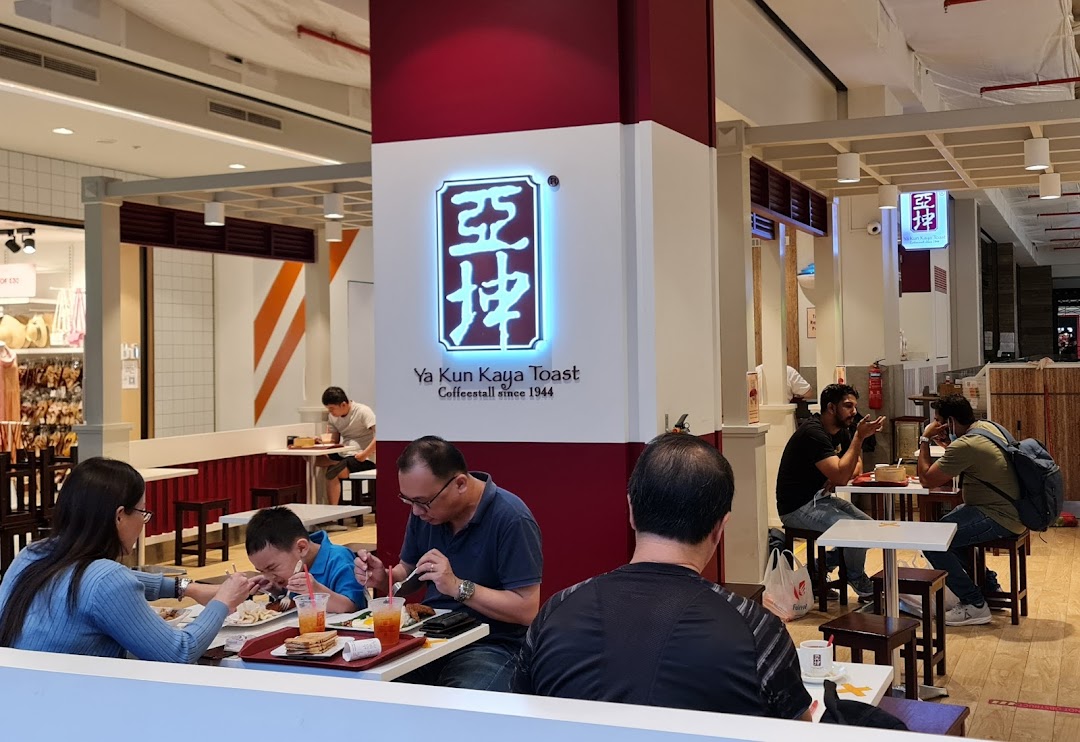 Customers are seated and enjoying meals inside the Ya Kun Kaya Toast cafe.