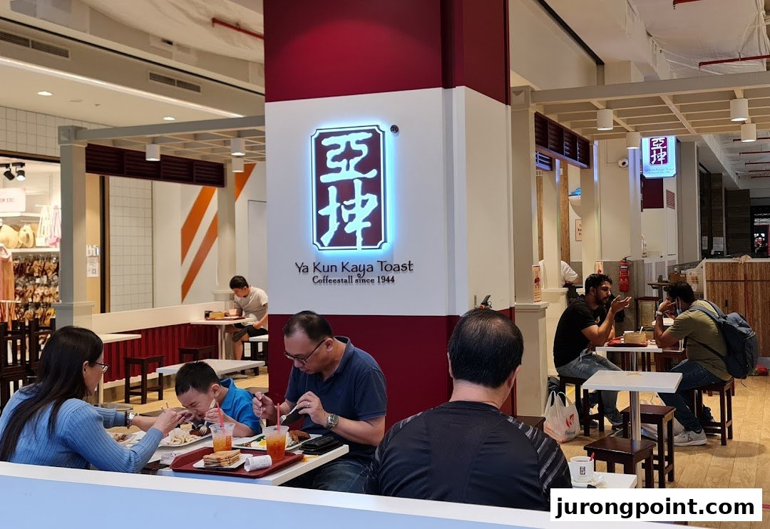 Customers are seated and enjoying meals inside the Ya Kun Kaya Toast cafe.