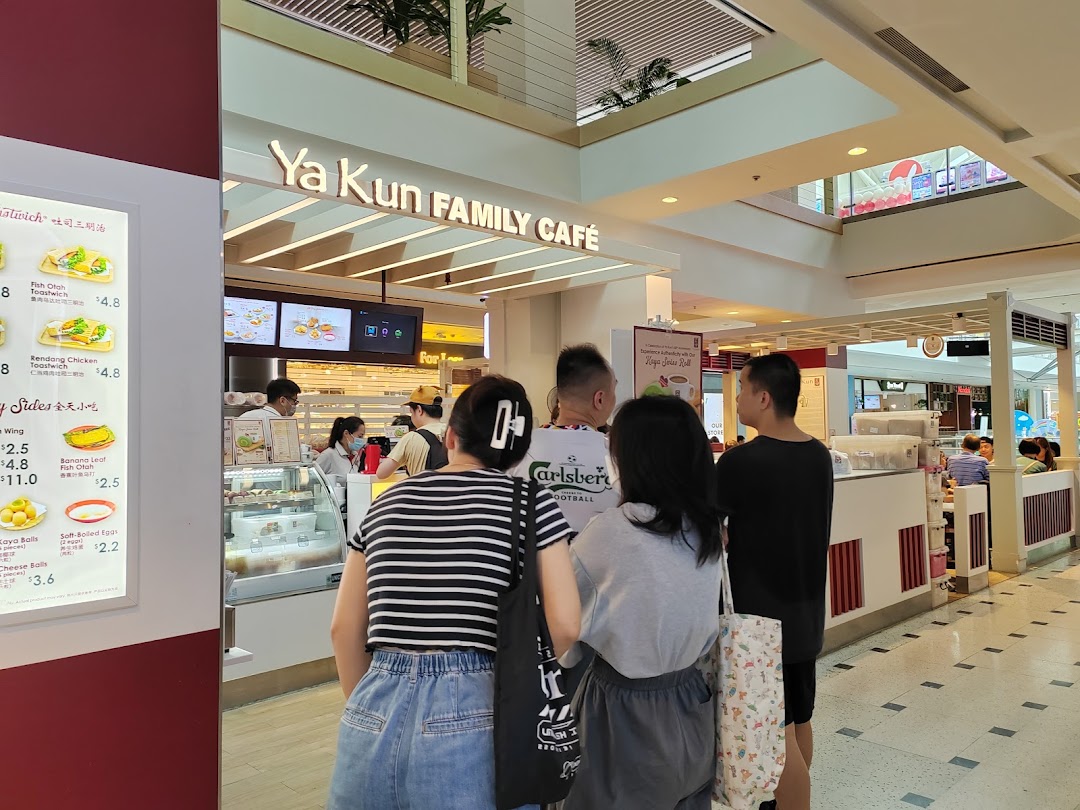 Customers queueing at the counter of Ya Kun Family Cafe, with a menu board visible on the left.
