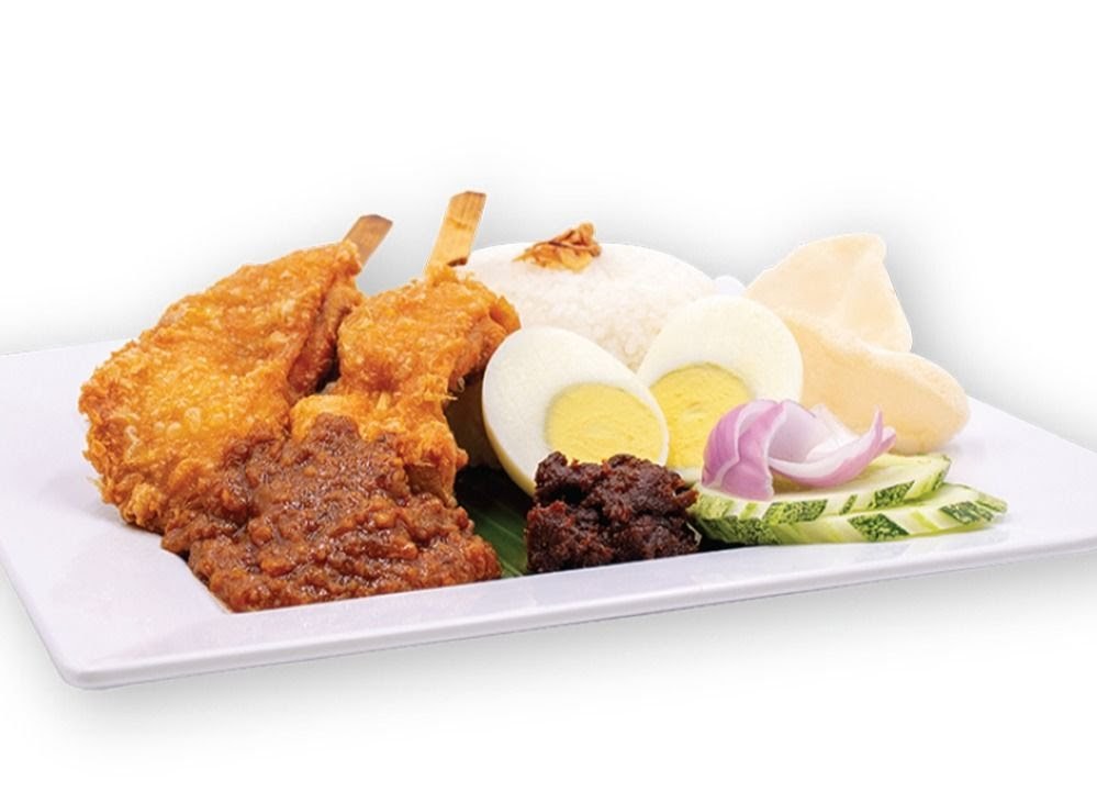 A plate of Nasi Lemak with fried chicken, fragrant rice, boiled egg, sambal, and fresh garnishes.