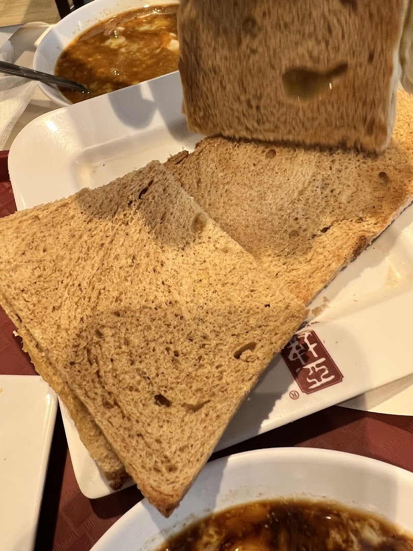 Close-up of traditional kaya toast and soft-boiled eggs, a classic breakfast set from Ya Kun Family Cafe.