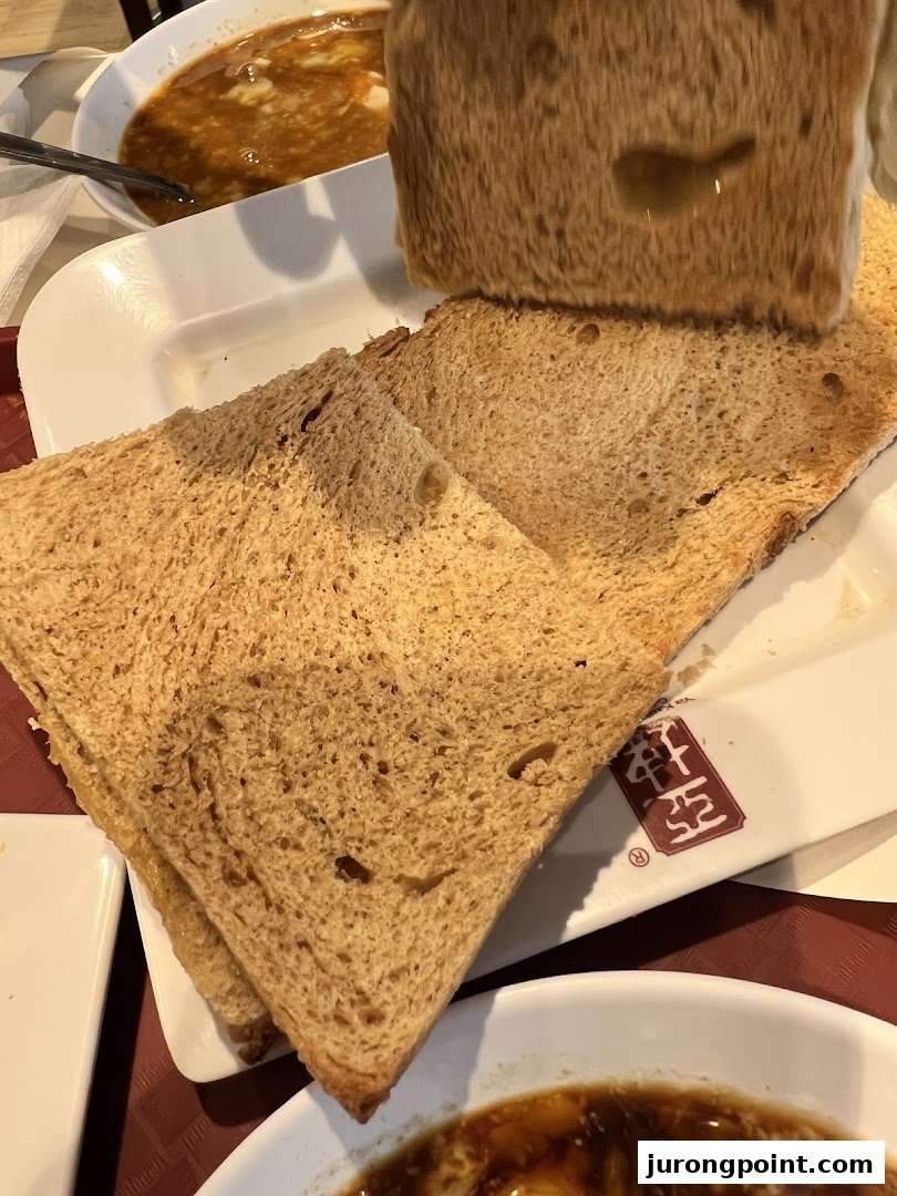 Close-up of traditional kaya toast and soft-boiled eggs, a classic breakfast set from Ya Kun Family Cafe.