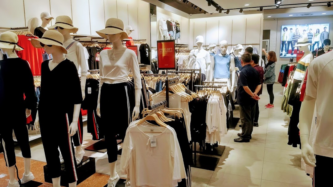 Interior view of YISHION clothing store with mannequins, clothing racks, and shoppers browsing apparel.
