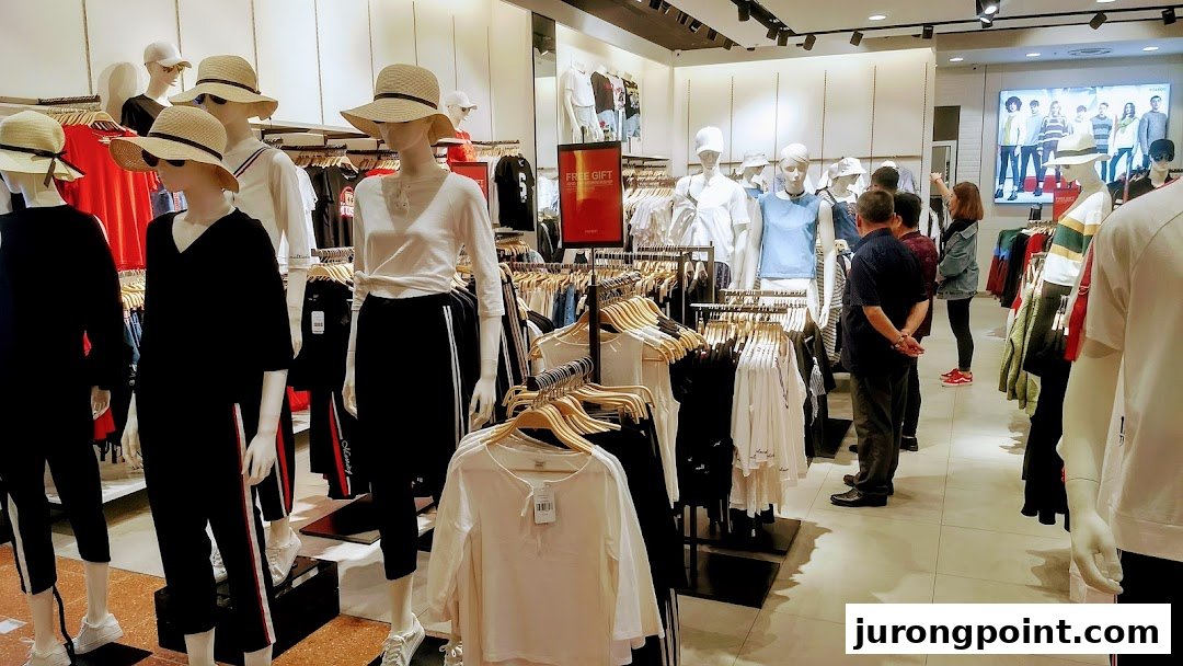 Interior view of YISHION clothing store with mannequins, clothing racks, and shoppers browsing apparel.