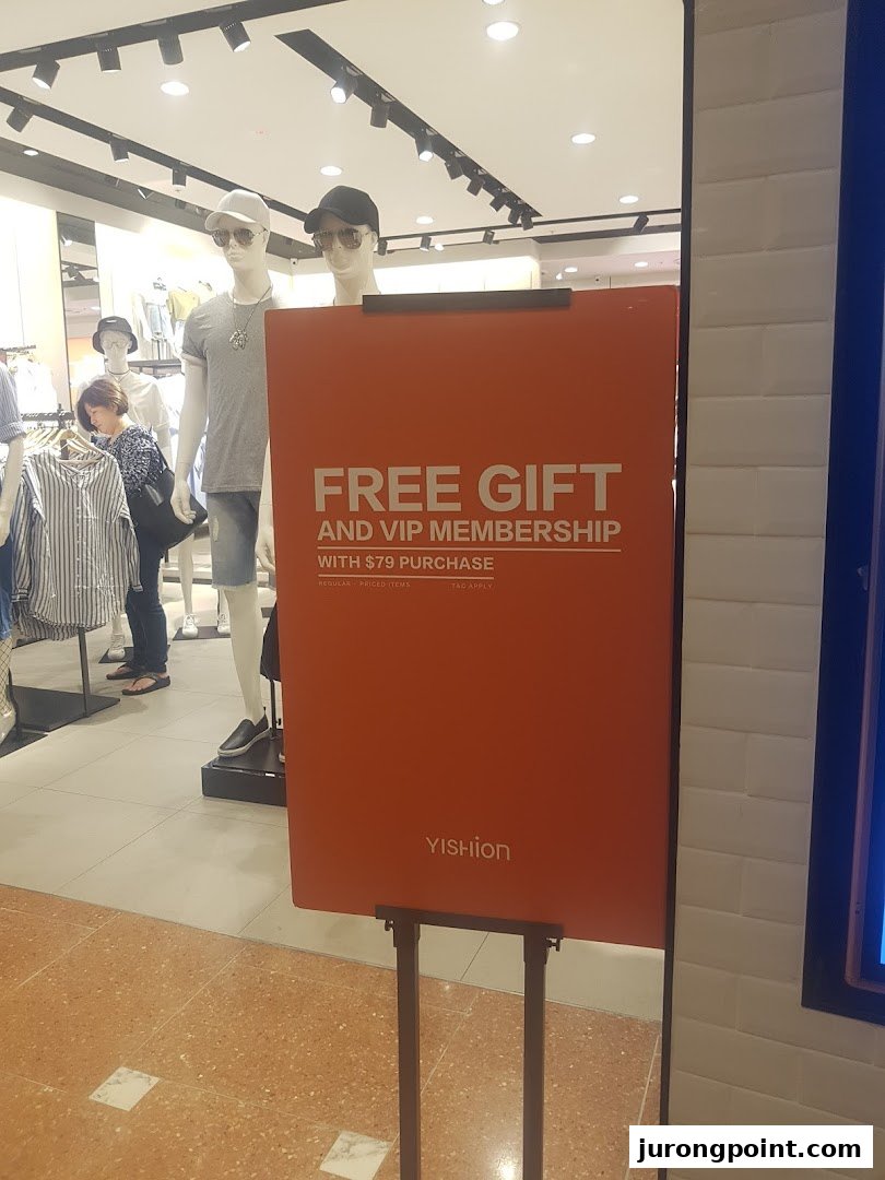 A promotional sign for YISHION inside the store, featuring mannequins and clothing.
