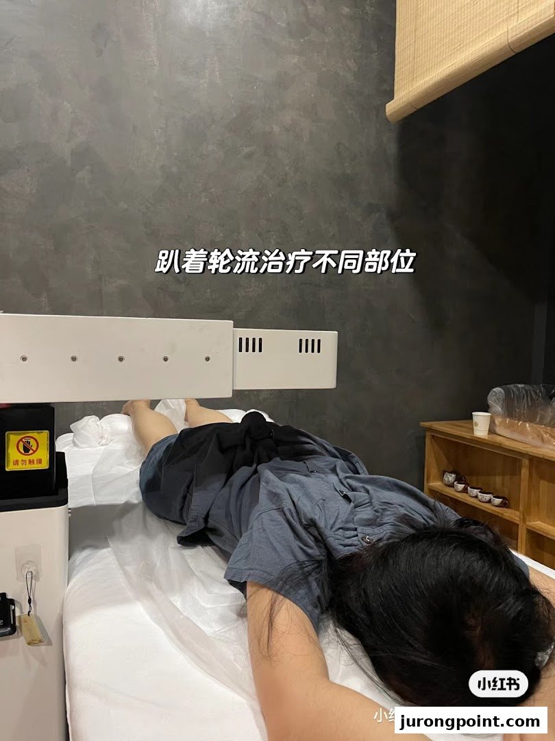 A person receives traditional Chinese medicine therapy on a treatment bed with an overhead device.