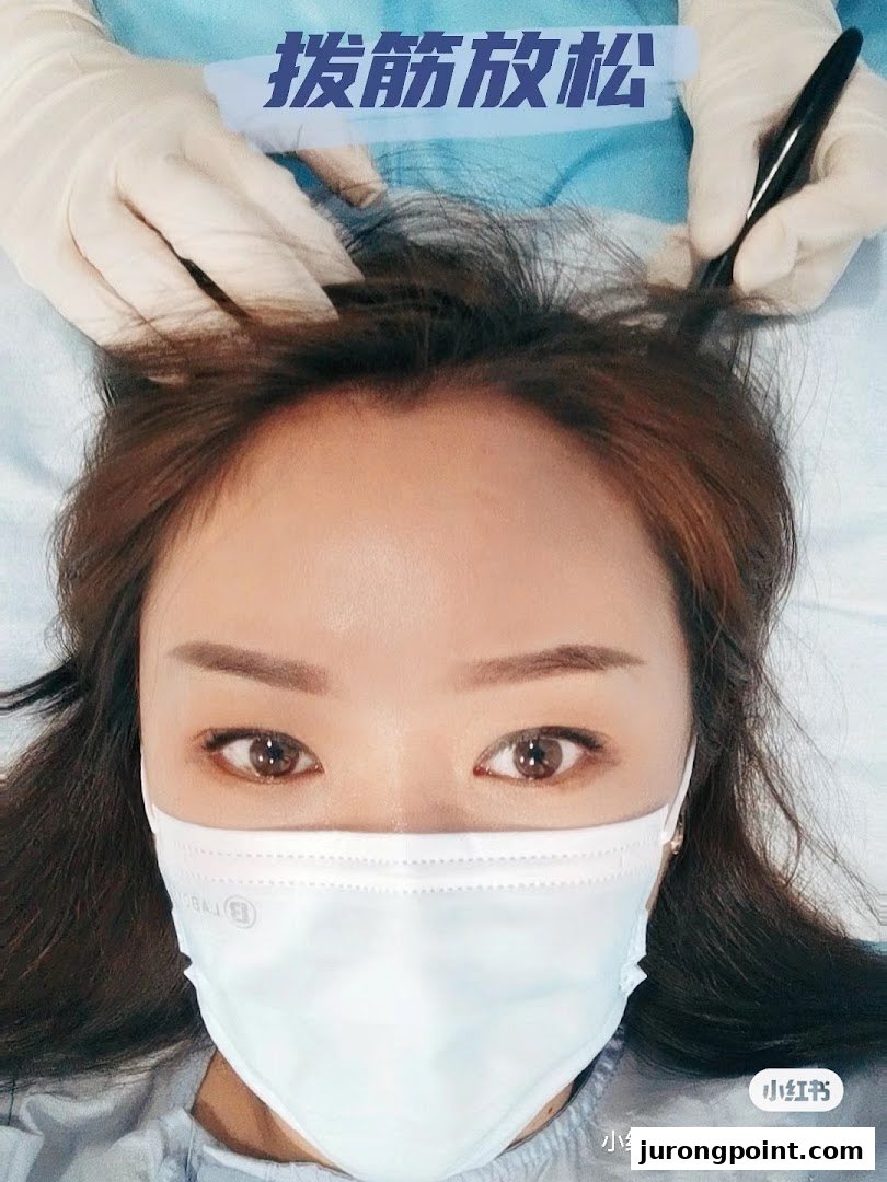 A client receives a relaxing head treatment from a gloved practitioner at Yong Kang TCM Clinic.