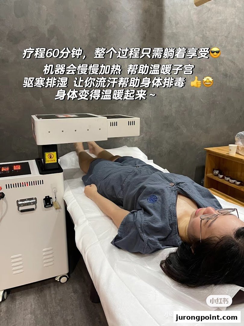 A person lies on a treatment bed receiving a warming therapy at a TCM clinic.