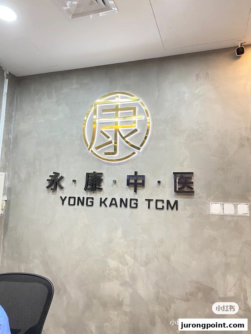 Interior view of Yong Kang TCM Clinic featuring its prominent logo and name on a textured wall.
