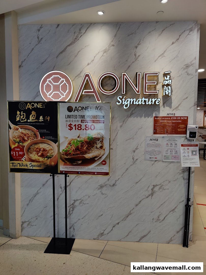 The entrance of A-One Signature restaurant featuring promotional displays for abalone porridge and deep-fried seabass.