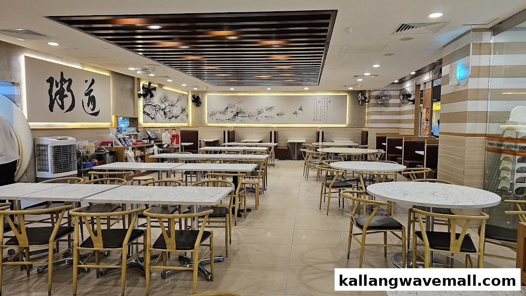 A spacious and well-lit dining area with numerous tables and chairs, featuring traditional Chinese wall art.