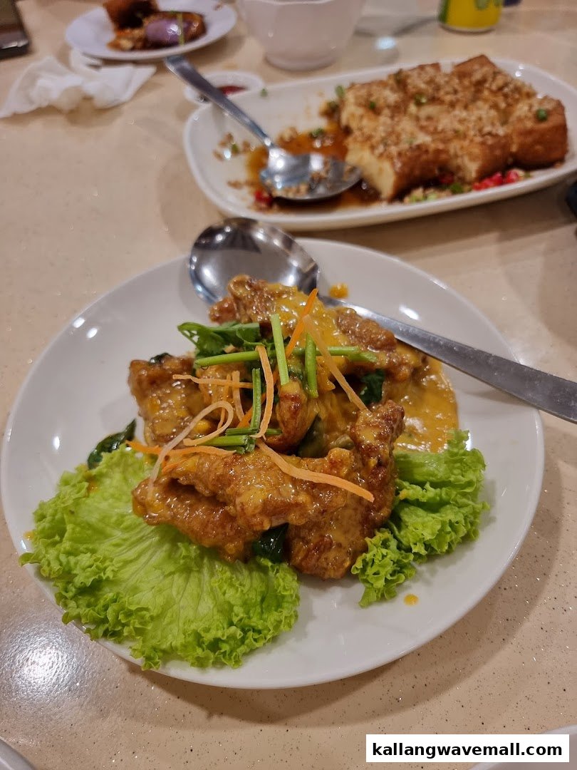 A close-up of a delicious golden-sauced dish with lettuce, with another dish visible in the background.