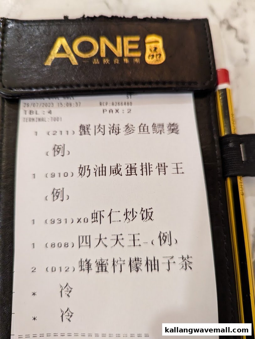 A close-up of a restaurant order slip from A-One Signature, showing ordered food and drink items.