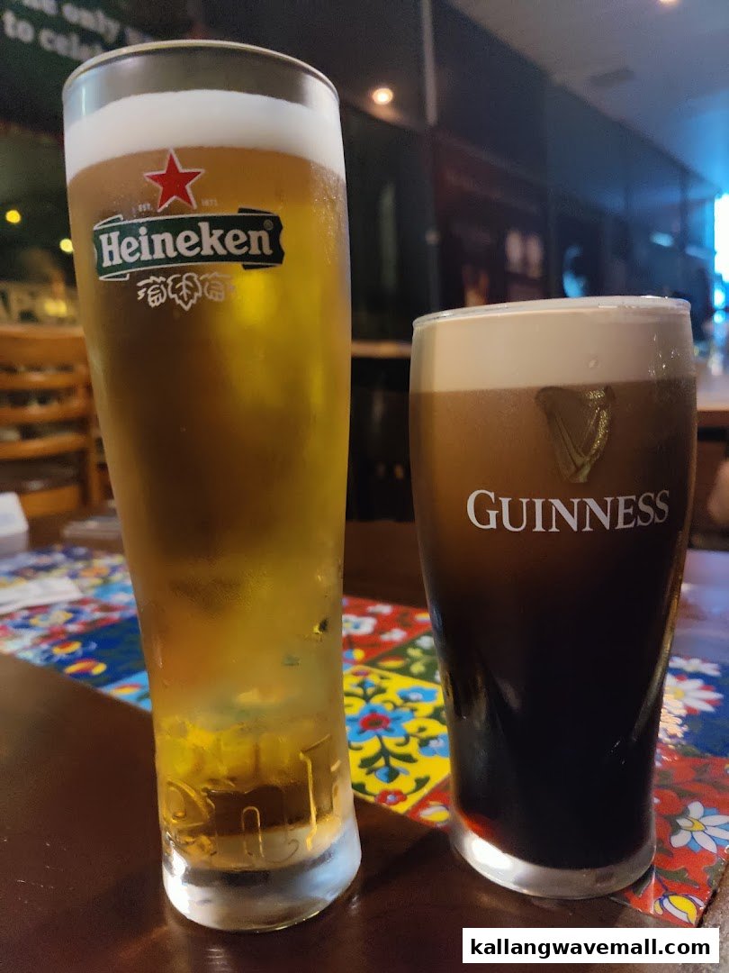 Two refreshing glasses of beer, Heineken and Guinness, on a colorful table at Al Capones.