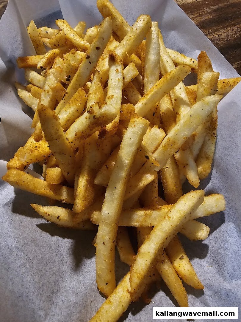 A close-up of golden, seasoned french fries served in a paper-lined basket.