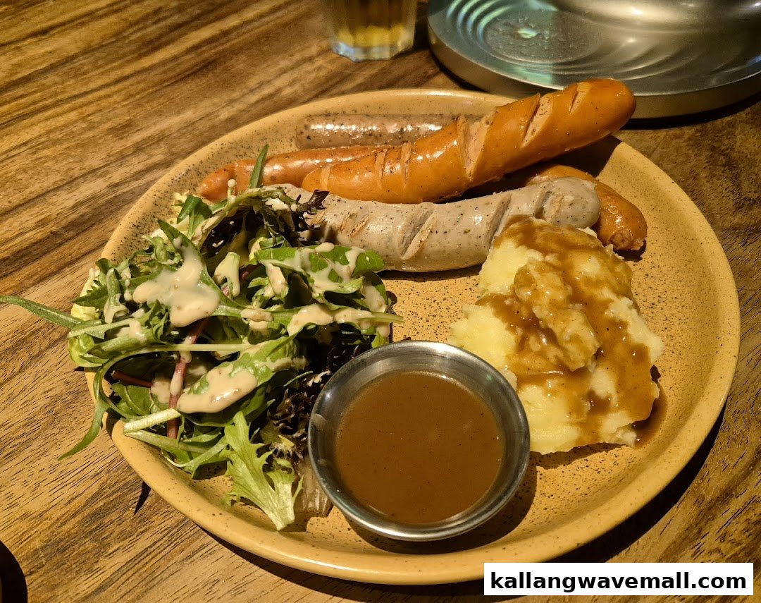 A hearty plate featuring sausages, mashed potatoes with gravy, and a fresh green salad.