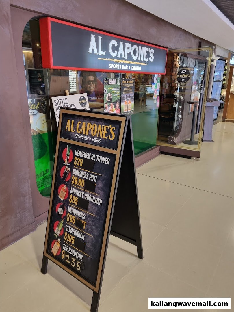 The shop front of Al Capone's Sports Bar + Dining, featuring its signage and an A-frame board with drink promotions.