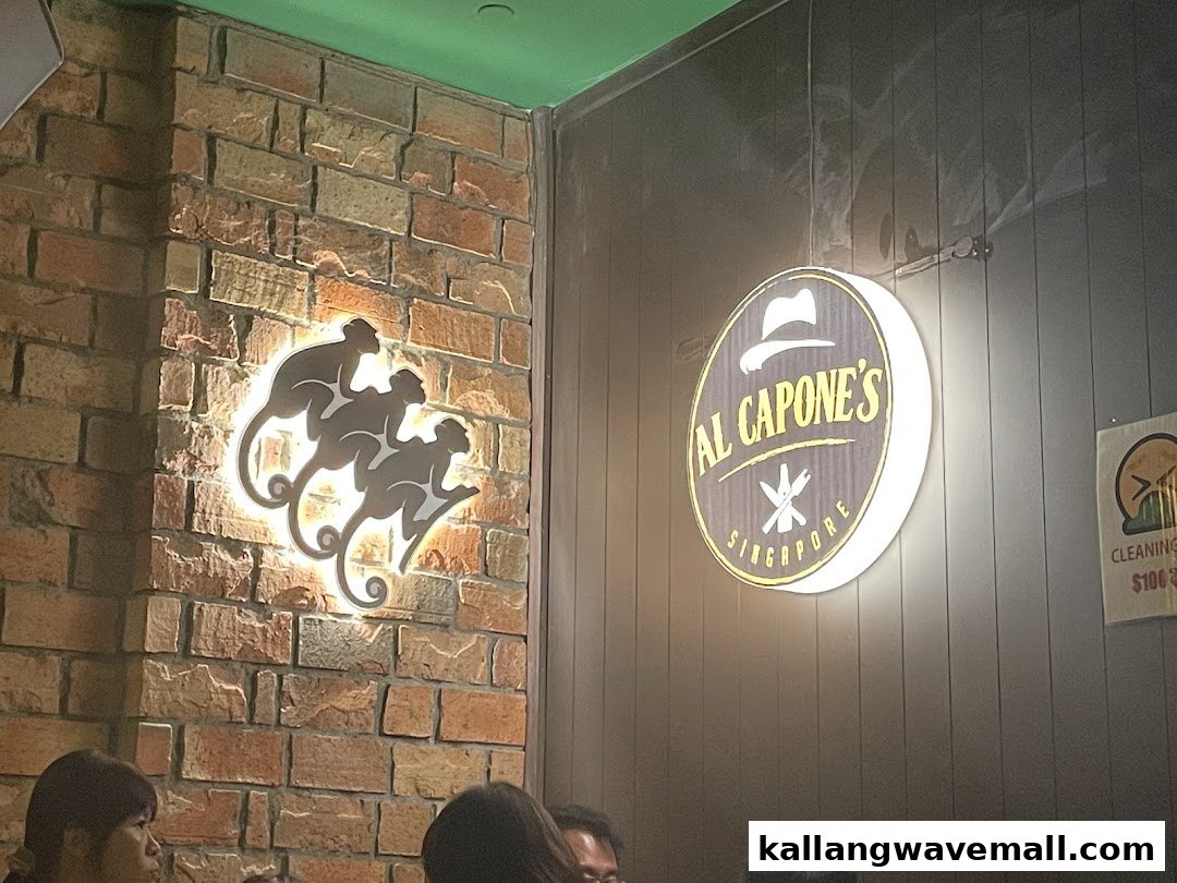 Interior shot of Al Capone's featuring illuminated signs on brick and paneled walls, with patrons visible.