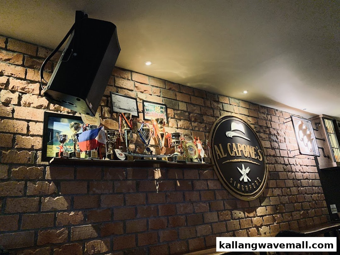 An interior shot of Al Capone's featuring a brick wall, the shop's logo, and a display of trophies.