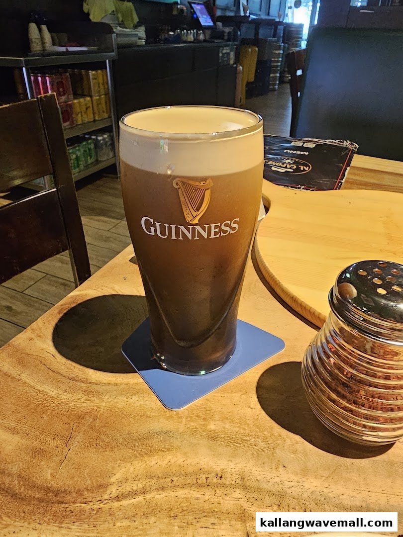 A perfectly poured pint of Guinness on a rustic wooden table inside Al Capones.