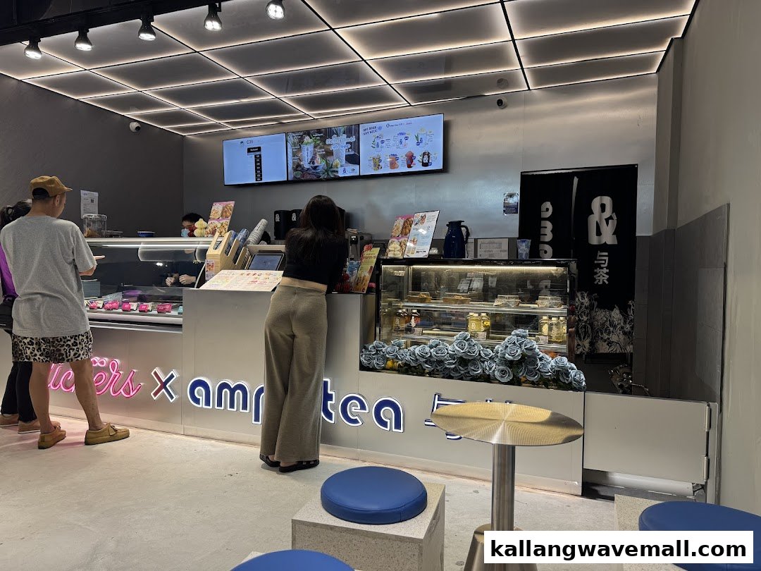 Customers order at the sleek counter of amps tea X Lickers, a modern tea and dessert shop.
