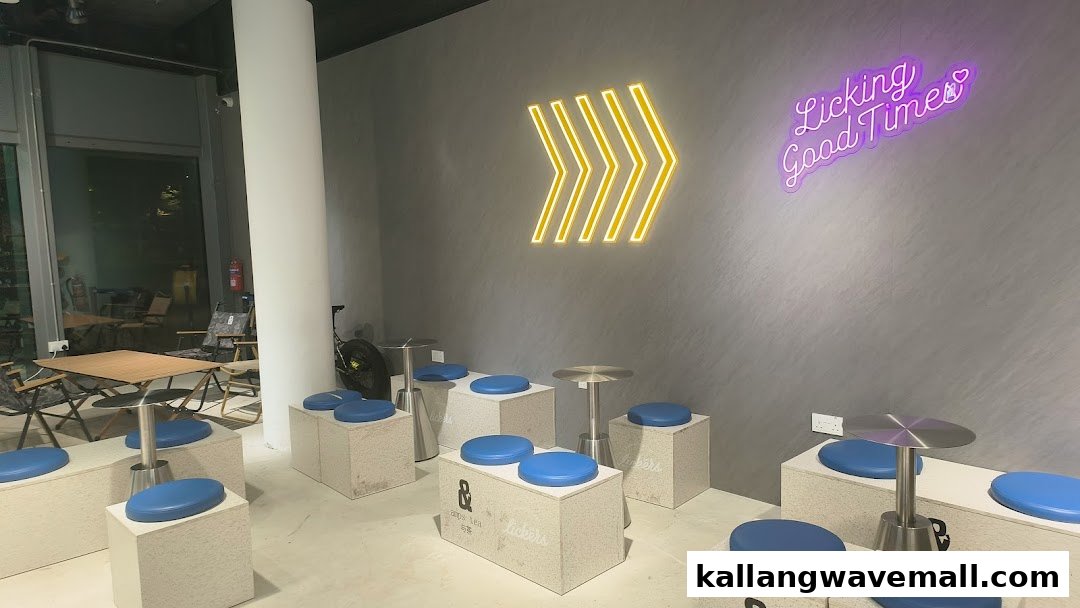 Modern interior of Amps Tea X Lickers with unique block seating, blue cushions, and neon wall art.